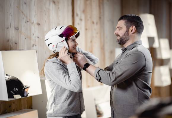 Mann berät Frau mit Skihelm 