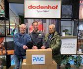 Von links: Carsten Mosch (P.A.C.), Sebastian Kropp (Dodenhof) und Oscar Brehm (Bremer Tafel e.V.) bei der symbolischen Übergabe der gespendeten Mütze.