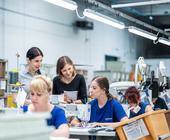 Veronika Becker (M.), Corporate Responsibility Managerin bei Lowa, spricht im Fertigungswerk des Schuhunterenhemnes in der Slowakei mit den Mitarbeiterinnen und Mitarbeitern.