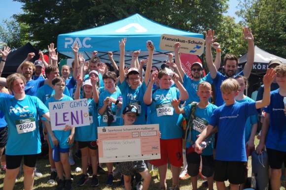 SchülerInnen der Franziskus-Schule freuen sich über Startplätze und Laufoutfit – gesponsert von P.A.C. im Wert von rund 500 Euro. Der symbolische Spendenscheck wurde beim MainCityRun 2025 übergeben.  
