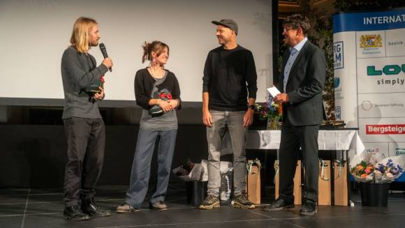 (v. l.) Festivalleiter Tom Dauer und Lowa-Marketingleiter Ulf Michels übergeben den Preis an Hanna Schneider und Paul Schweller. 